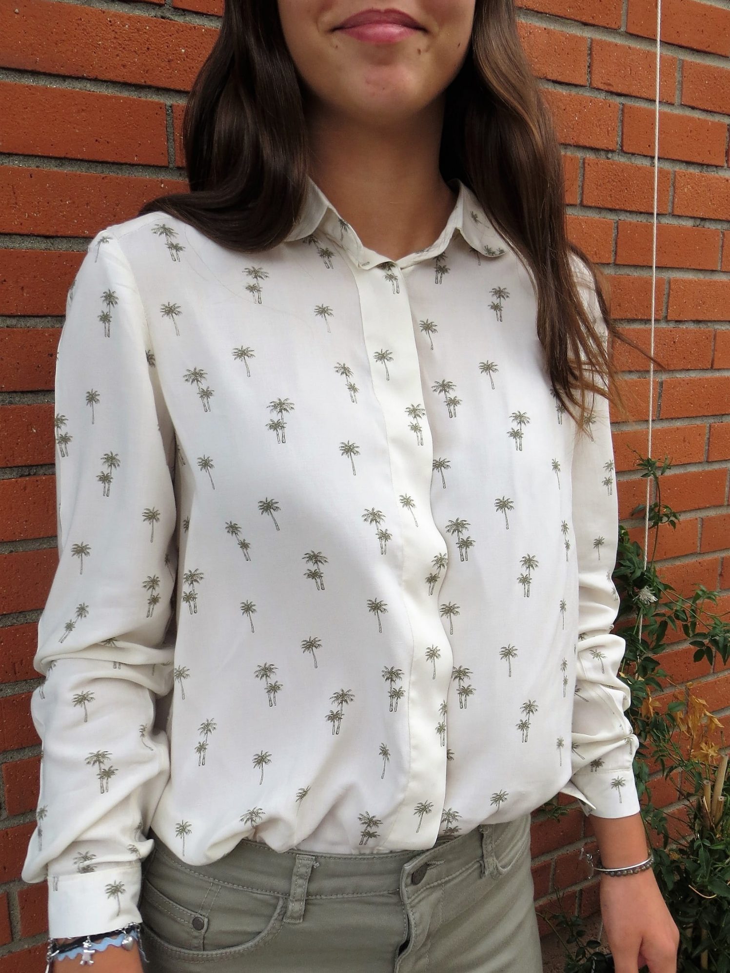 Une chemise manches longues, boutonnage caché avec sous-patte, motif palmiers